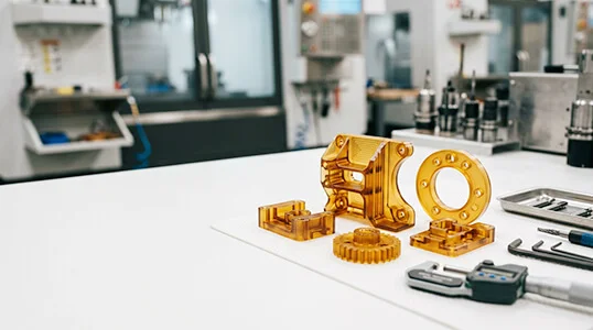 ULTEM (PEI) amber translucent stock and CNC machined high-heat plastic parts on clean workbench